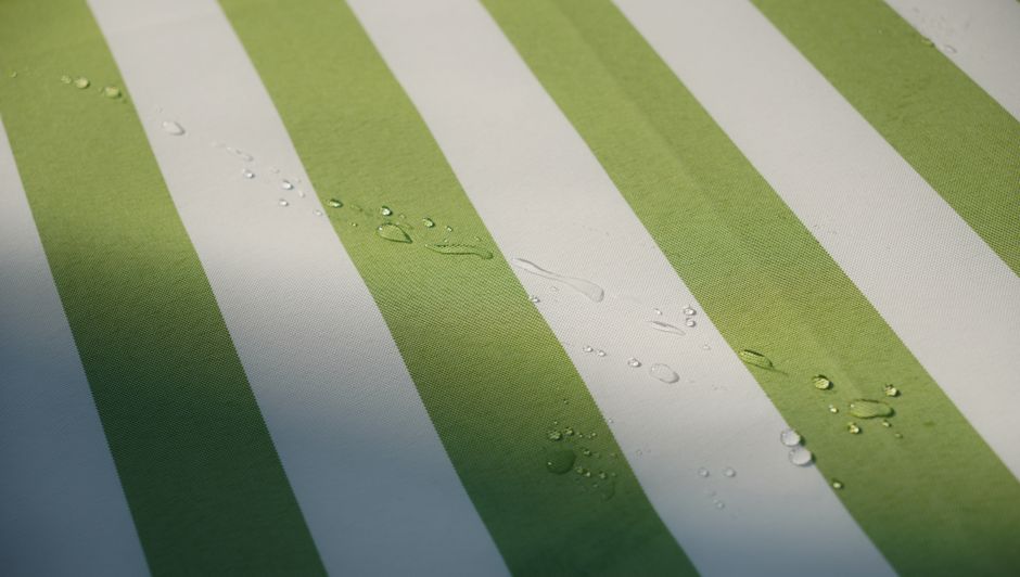 Green and white striped fabric with translucent water droplets, showcasing texture and detail.